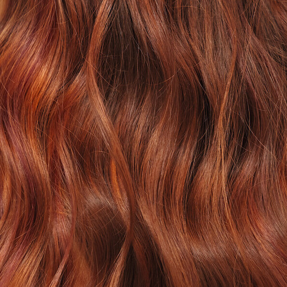 Close-up of wavy, dark red hair that’s been colored using Koleston Perfect by Wella Professionals