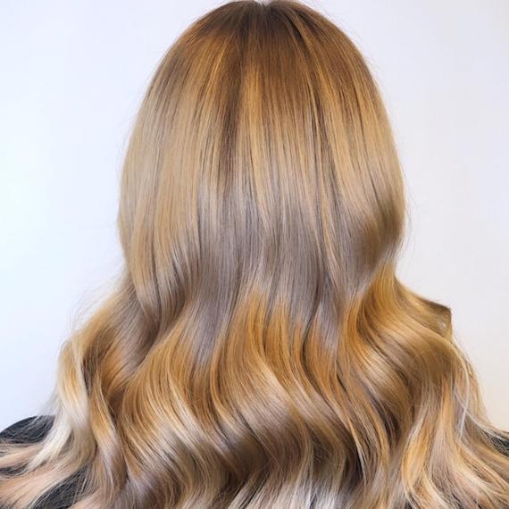 Back of woman’s head with wavy, beige blonde hair, created using Wella Professionals.