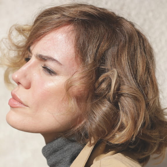 Side profile of woman with honey blonde, short, tousled hair, created using Wella Professionals.