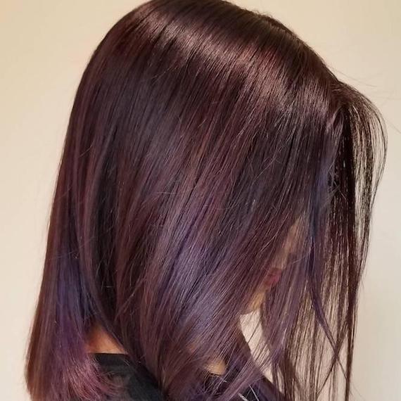 Side profile of woman with dark mahogany hair, created using Wella Professionals