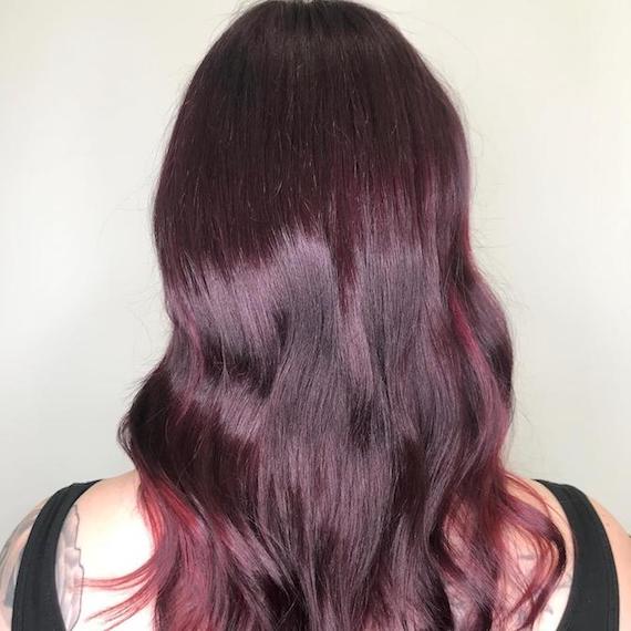 Back of woman’s head with long, wavy, shiny, mahogany hair, created using Wella Professionals.