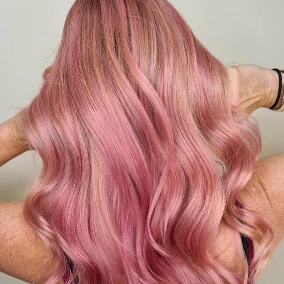 Back of woman’s head with long, wavy, pink hair, created using Wella Professionals.