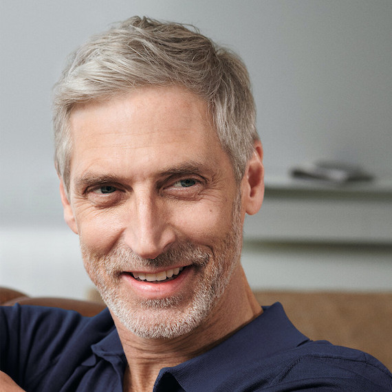 Man with short grey hair smiles.