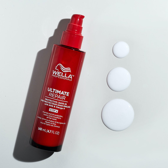 Bottle of ULTIMATE REPAIR Protective Leave-In on a white surface.