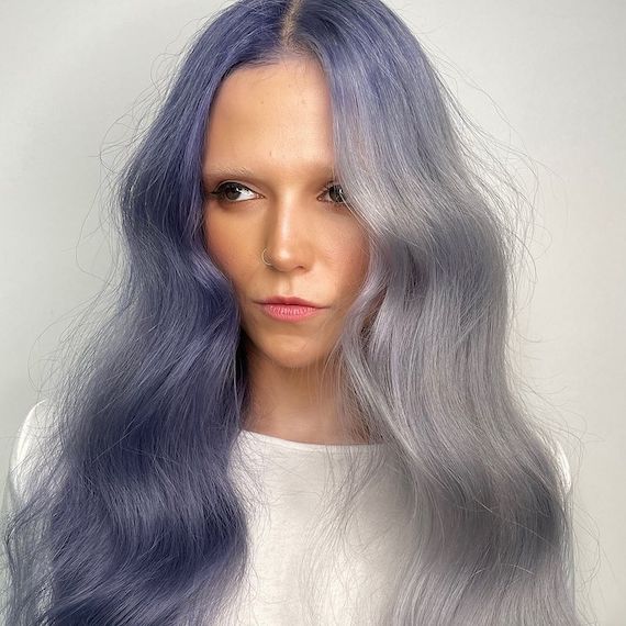 Model with grey-blue hair on one side and navy blue hair on the other.