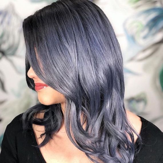Side profile of model with wavy, navy blue-grey hair.