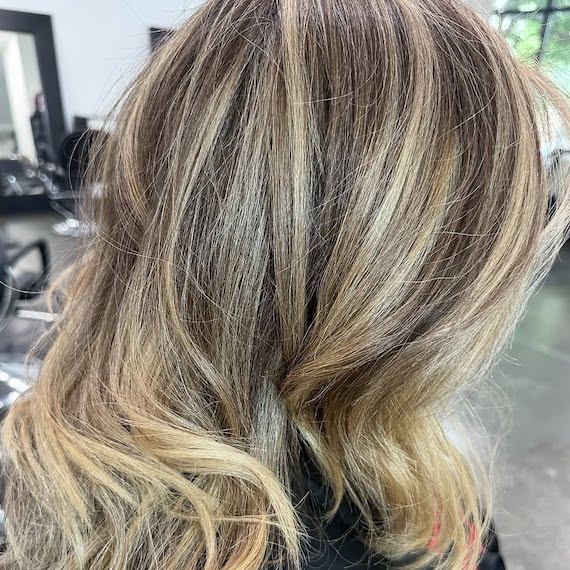 Model with brown hair featuring butterscotch blonde, chunky highlights.