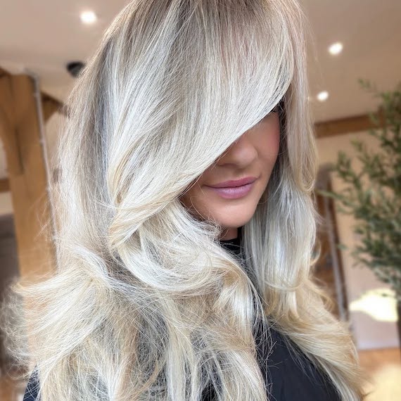 Model with a bombshell blow-dry in a multi-tonal platinum blonde shade.