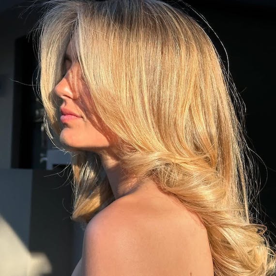 Model with bouncy blow-dried, golden blonde hair.