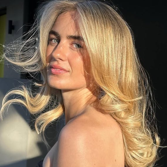 Model with bouncy blow-dried, golden blonde hair.