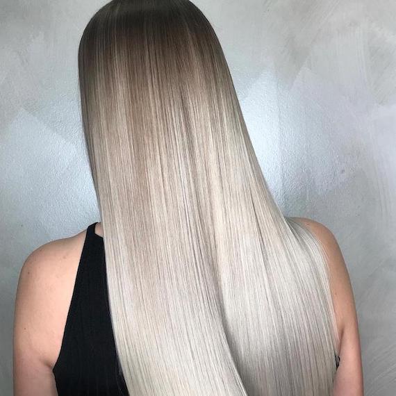 Back of woman’s head with long, straight, silky, silver ombre hair, created using Wella Professionals.