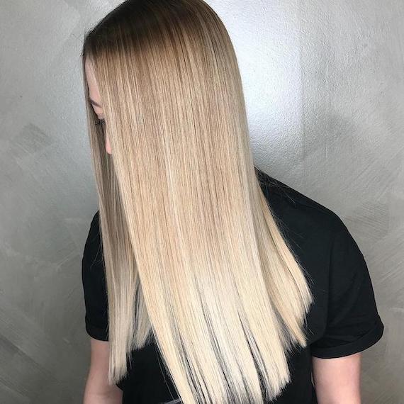 Photo of woman with long, straight, silky, blonde ombre hair, created using Wella Professionals.