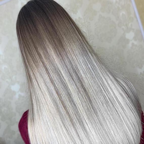 Back of woman’s head with long, straight, silky, silver ombre hair, created using Wella Professionals.
