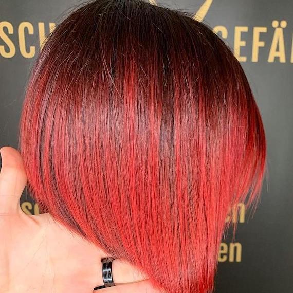 Side profile of woman with red ombre hair cut into a bob, created using Wella Professionals.