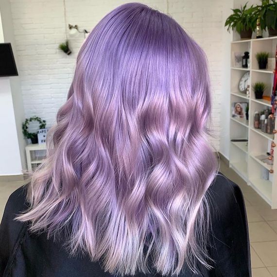 Back of model’s head with tousled, pastel purple ombre hair.