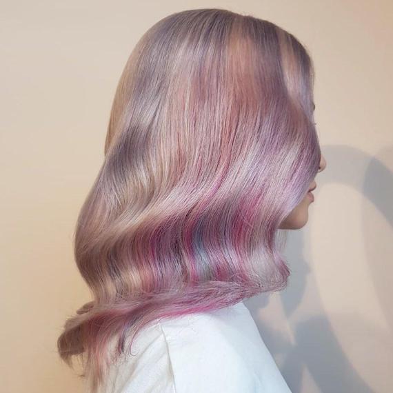 Side profile of model with glossy, pastel rainbow ombre hair.