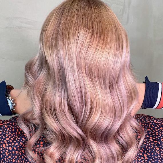 Back of woman’s head with long, wavy, pastel pink and blonde hair