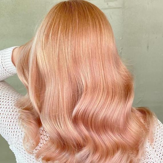 Back of woman’s head with wavy, rose gold hair, created using Wella Professionals.