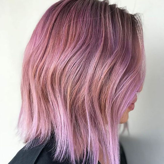 Side profile of model with a short bob haircut, featuring a candyfloss pink ombre.