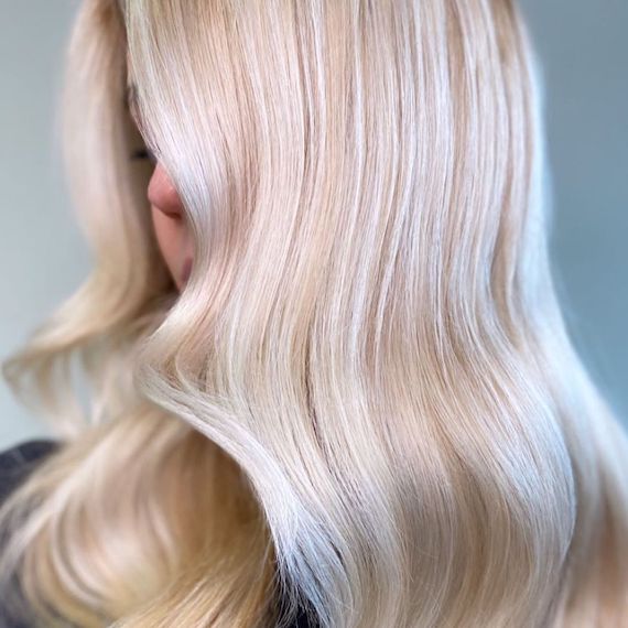 Side profile of model with vanilla blonde hair and platinum highlights.