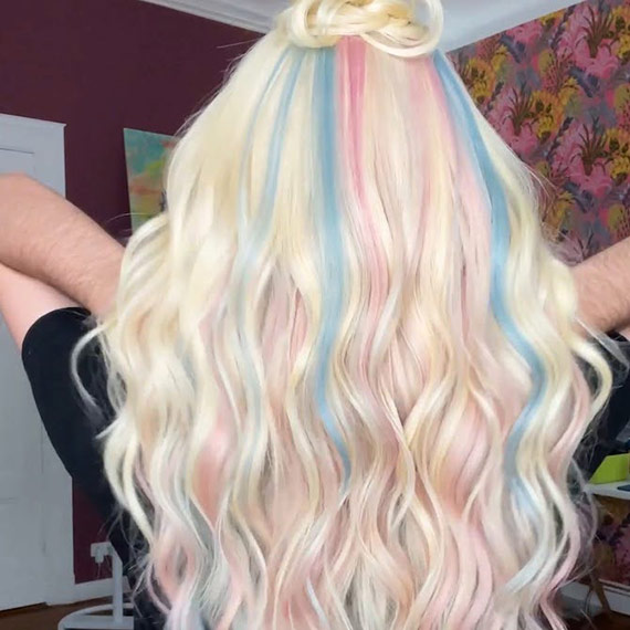 Model’s long, blonde hair features pastel pink and blue tones to symbolise the Transgender flag.