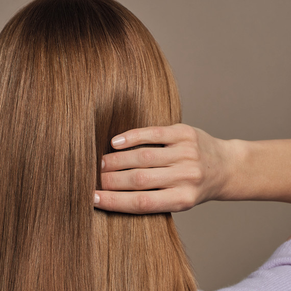Back of model’s head with straight, light brown hair.