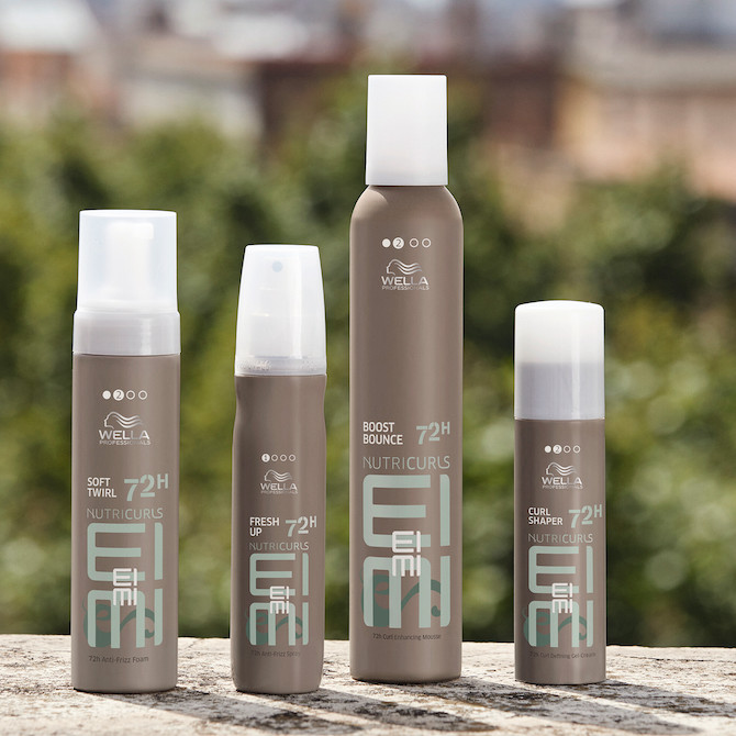 Collection of Wella EIMI styling products lined up on a stone surface.