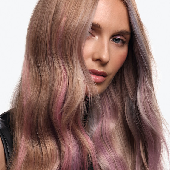 Model with ash blonde hair featuring pink and purple pastel highlights.