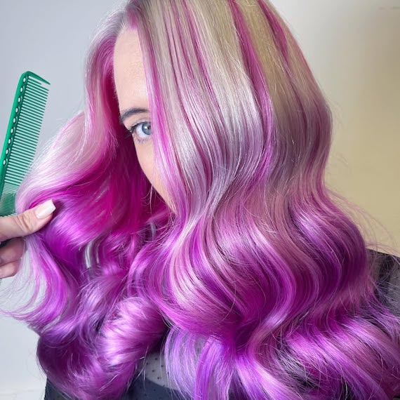 Model with platinum blonde hair featuring pink and purple highlights.