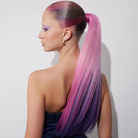 Model with ultra-long, pink and purple hair tied back in a sleek pony.