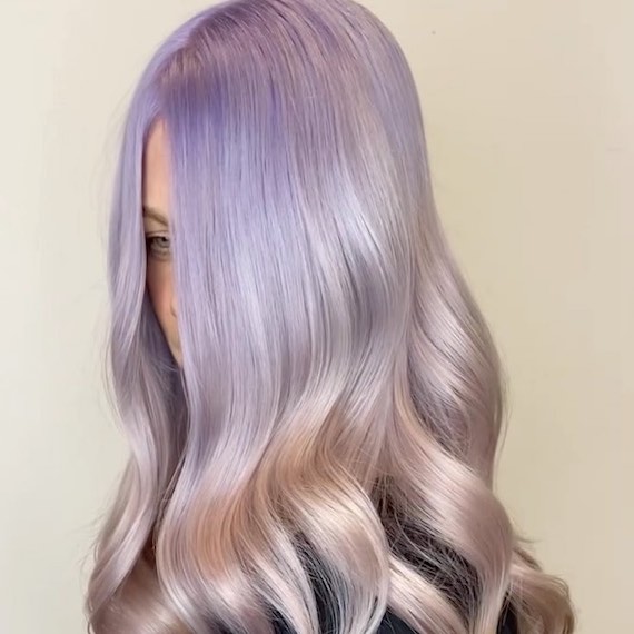 Model with long, loosely waved, purple and pink ombre hair.