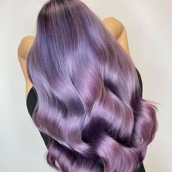 Back of model’s head with long, loosely curled violet to lilac ombre hair.