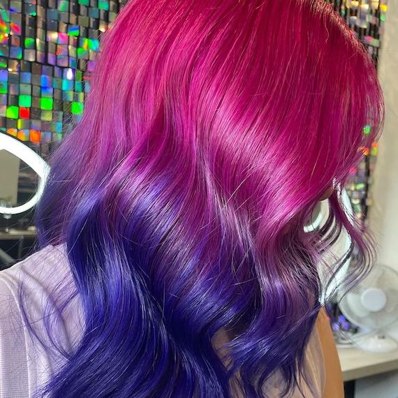 Side profile of model with magenta pink to vibrant purple ombre hair.