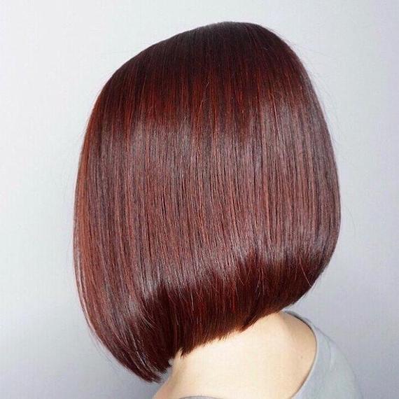Side profile photo of woman with short blunt bob and a dark red hair color, created using Wella Professionals. 