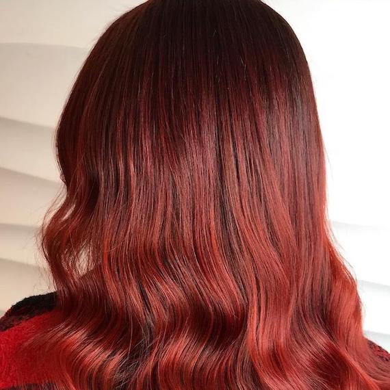 Photo of the back of a woman’s head with long, red ombre hair, created using Wella Professionals.