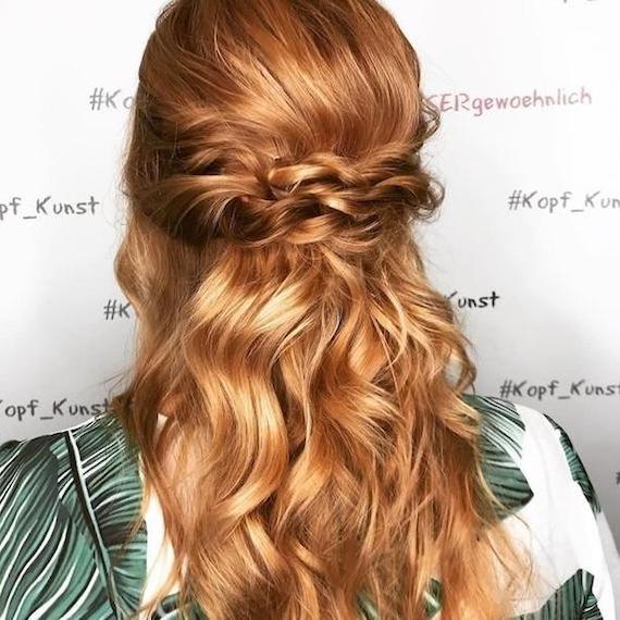 Photo of the back of a woman’s head with strawberry blonde hair styled into a half-up braid, created using Wella Professionals. 