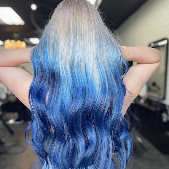 Back of person’s head reveals their cool platinum blonde to blue reverse ombre hair