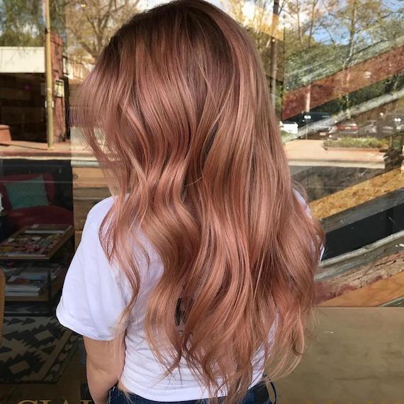 Back of woman’s head with long and wavy rose gold hair, created using Wella Professionals.