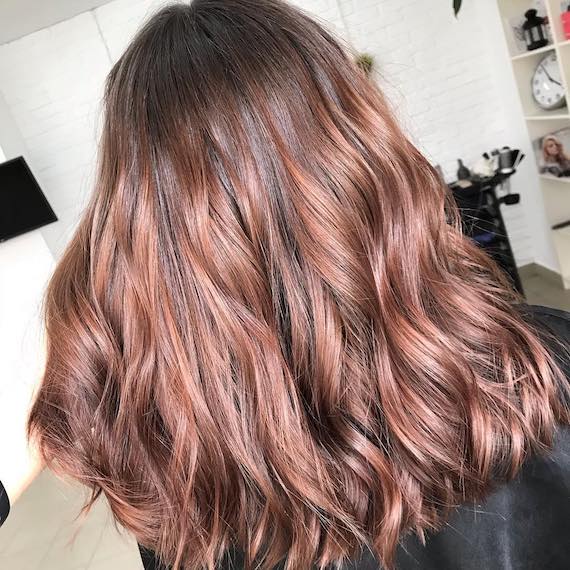 Back of woman’s head with long and wavy, rose brown hair, created using Wella Professionals.