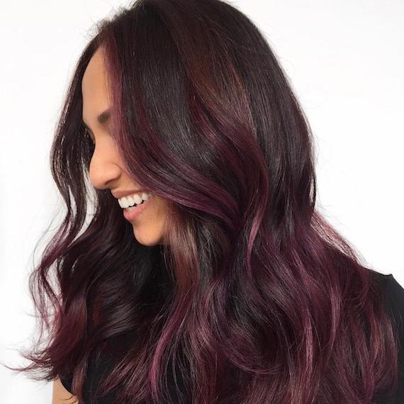 Model with long, wavy, dark brunette hair that features pink through the tips, created using Wella Professionals.