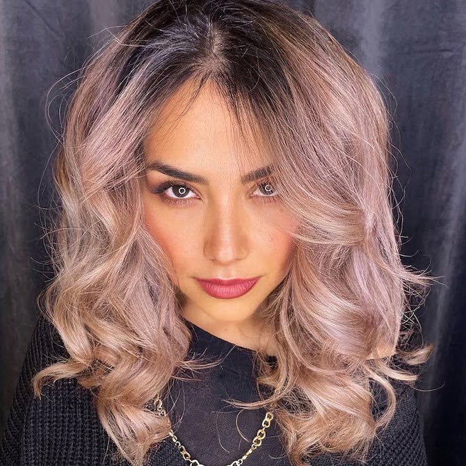 Model with dark roots that melt into a rose gold shade on the lengths.