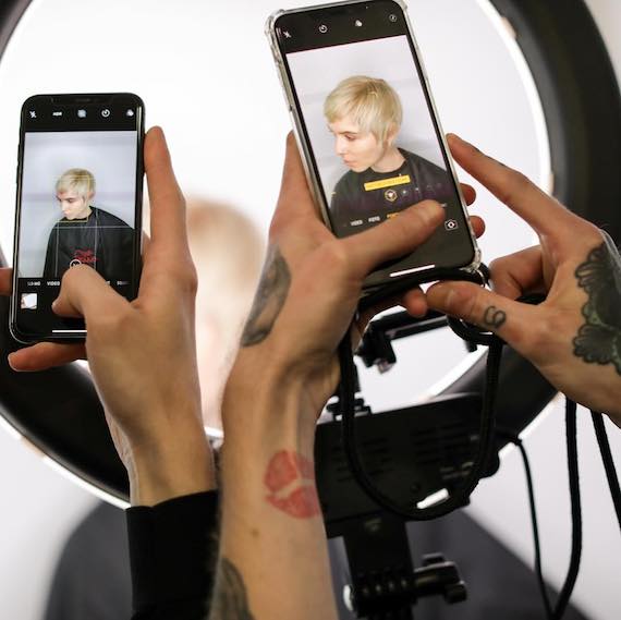 Blonde woman with pixie crop having her photo taken at a Wella Professionals event.