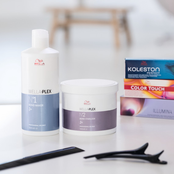 Wella Professionals WellaPlex products stood on a white table next to a box of Koleston Perfect, ColorTouch & Illumina Color