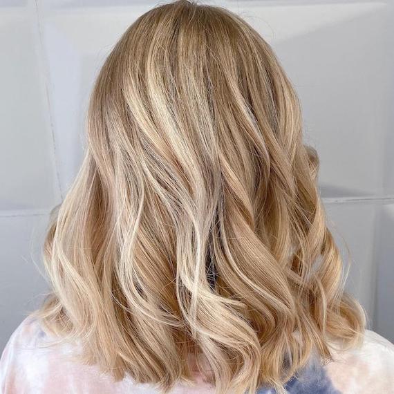 Photo of the back of a woman’s header with shoulder-length, sandy blonde hair, created using Wella Professionals. 