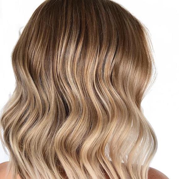 Side profile photo of woman with sandy blonde ombre hair, created using Wella Professionals. 