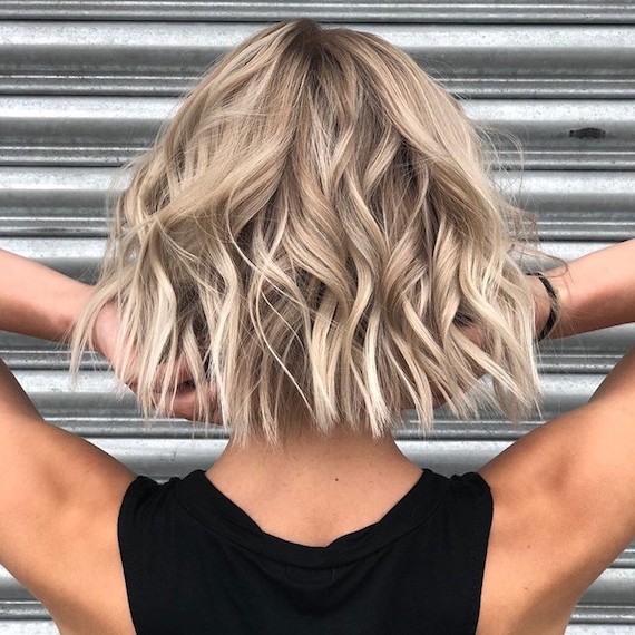 Back of model’s head with short bob haircut styled in tousled waves.