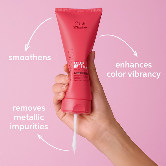 A hand squeezes a bottle of INVIGO Brilliance Vibrant Color Conditioner.