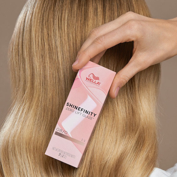 Close-up of straight, light blonde hair with a box of Shinefinity Color Glaze held in the foreground.