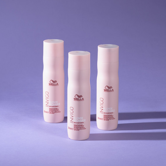 Three bottles of Wella’s INVIGO Cool Blonde Shampoo on a purple background. 