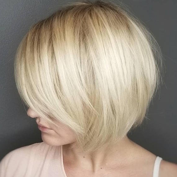 Side profile of woman with layered short blonde hairstyle, created using Wella Professionals.